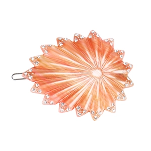 Détail d'une pince à cheveux étoile de mer en résine orange avec strass brillants