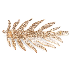 Close-up detail of leaf-shaped hair clip with sparkling golden glitter inside clear resin