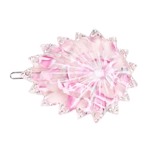 Détail de la pince à cheveux fleur en acétate rose avec strass et clip métallique