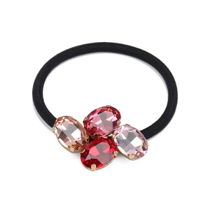Detailed macro view of oval crystal clusters on a black elastic hair tie with gold setting