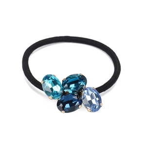 Detailed view of cluster oval blue crystal rhinestones on a black elastic hair tie accessory