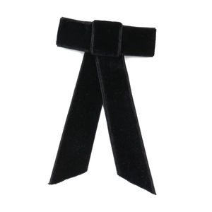 Detail of elegant black velvet bow hair clip with long ribbons and smooth texture
