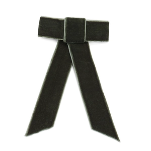 Close-up detail of dark green velvet bow hair clip with long elegant ribbons
