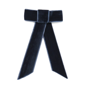 Detail of navy blue velvet bow hair clip with long ribbons and elegant texture
