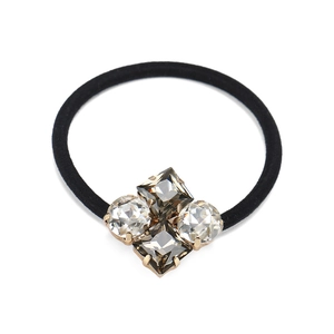 Dettaglio elastico capelli cristallo con pietre geometriche incastonate in oro su nero