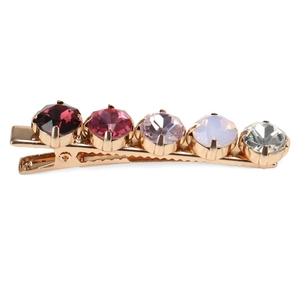 Detailed macro view of vibrant colorful rhinestones on a gold alloy hair clip base