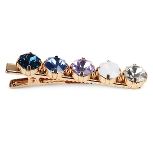 Detail of elegant gold-plated alligator hair clip with five multi-colored gradient crystals