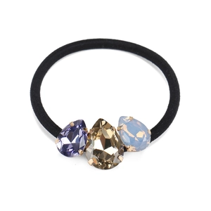 Détail de l'élastique à cheveux avec cristaux en forme de larme violets, dorés et bleus