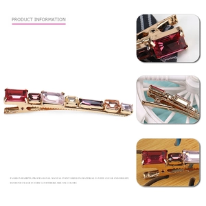 Detail view of gold-plated geometric hair clip with colorful rectangular crystals