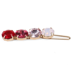 Detailed view of gold hair clip with colorful gradient crystals in four-prong settings