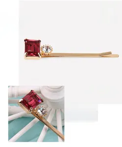 Détail de pince à cheveux de luxe avec cristal rouge taille émeraude et strass blancs
