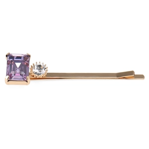 Détail d'une barrette dorée avec cristal violet taille émeraude et petit strass transparent