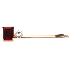 Détail de pince à cheveux de luxe avec pierre rouge et cristal blanc sur monture dorée