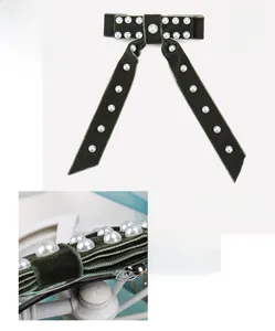 Vue détaillée de la barrette à nœud en velours avec perles et dimensions du clip