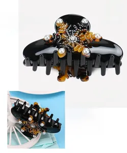 Detail view of large acetate hair claw with rhinestones and pearls, size 5x8.9cm