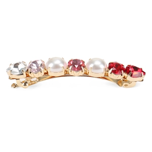 Barrette à cheveux dorée avec cristaux colorés et perles sur un fond blanc pur