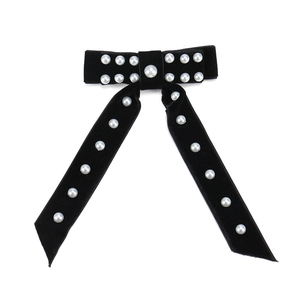 Vue détaillée de la barrette à cheveux en velours avec perles élégantes et tissu doux