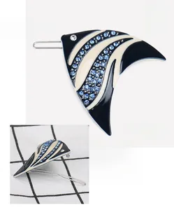 Detail of fish-shaped acetate hair clip with blue rhinestones and metal clip base