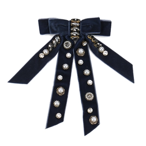 Détails d'un nœud en velours bleu foncé avec strass marquise et perles sur l'agrafe