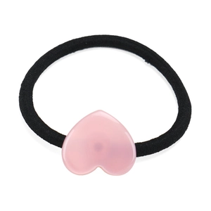 Dettaglio dell'accessorio in resina rosa a forma di cuore su elastico per capelli nero