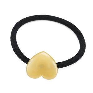 Dettaglio di elastico per capelli nero con un grazioso ciondolo a cuore in resina gialla