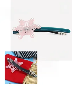 Detail of pink acetate snowflake hair clip with pearls and green base measuring 10.5x4.5cm