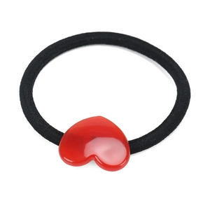 Dettaglio dell'elastico nero ad alta elasticità con ciondolo a cuore rosso lucido