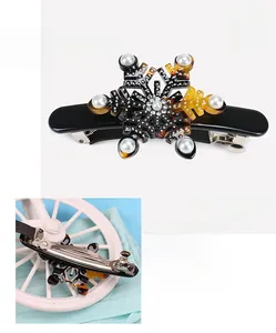 Detailed view of snowflake hair clip made of black acetate with pearls and rhinestones