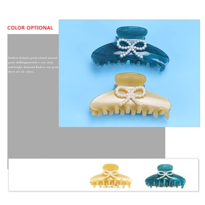 Elegant acetate claw clip with pearl bow design available in multiple marble colors
