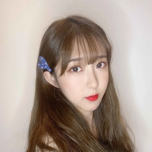 Gros plan sur une pince à cheveux papillon bleue à pois dorés portée par un mannequin