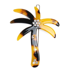 Detailed view of palm tree hair clip with tortoiseshell pattern and sparkling rhinestones