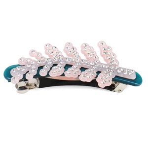 Detailed close-up of leaf-shaped acetate hair clip with pink rhinestones and metal spring