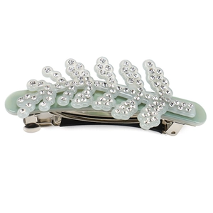 Detail view of a leaf-shaped acetate hair clip with rhinestones and a metal spring clamp