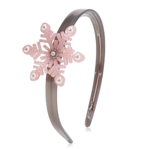 Detail eines rosa Schneeflocken-Charms mit Perlen und Strass auf grauem Acetat-Haarreif