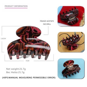 Detail view of red and black marble acetate hair claw with 7cm size dimensions