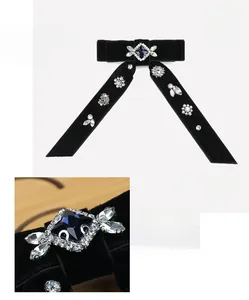 Detail of black velvet bow hair clip with sparkling rhinestones and a blue crystal center