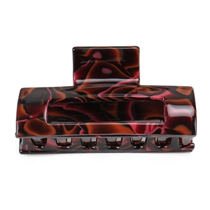 Close-up of a large tortoiseshell acetate hair claw with brown and pink marble pattern