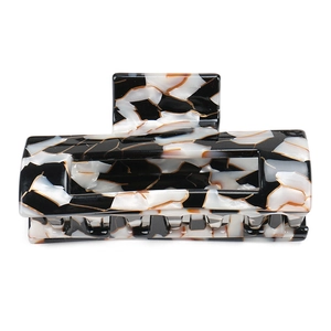 Detail view of large square acetate hair claw with black and white marble pattern
