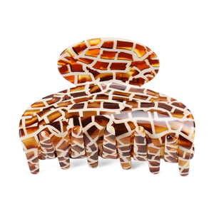 Detailed macro view of acetate hair claw clip with amber and brown mosaic patterns