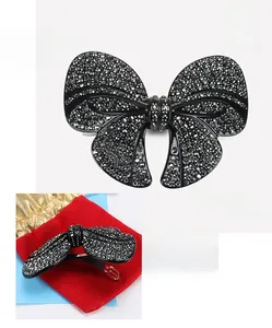 Detail view of large acetate bow hair clip with black rhinestones and spring clasp