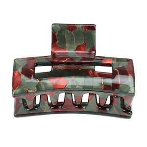 Detailed close-up of marble pattern hair claw clip in green, burgundy and gold colors