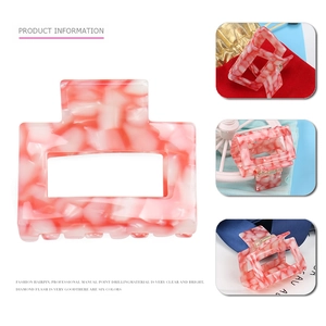 Detail of square acetate hair claw clips with pink marble texture and handmade crystals