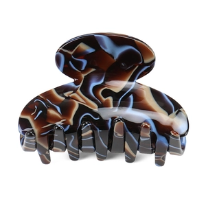 Close-up of tortoise acetate hair claw clip with blue marble pattern and metal spring