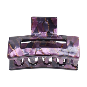 Close-up of geometric acetate hair claw featuring purple marble pattern with gold veins