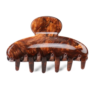 Vue détaillée d'une grande pince à cheveux en acétate à motif écaille de tortue ambre