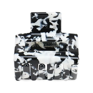 Close-up of geometric acetate hair claw clip with black and white marble pattern texture