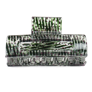 Detail of large acetate hair claw clip featuring green white and purple abstract patterns