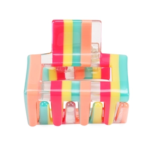 Detail showing the colorful rainbow stripe pattern on a medium square hair claw clip