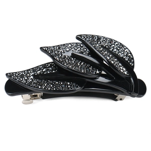 Detailed macro view of retro leaf-shaped hair clip with shimmering black rhinestones