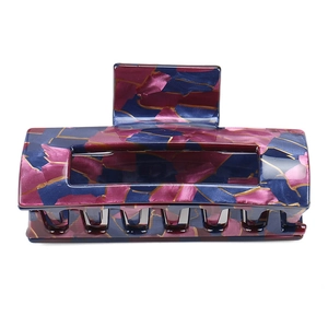 Detailed close-up of large acetate hair claw clip with purple geometric marbling patterns